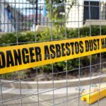 Yellow caution tape warning the public on a construction site - danger asbestos dust hazard